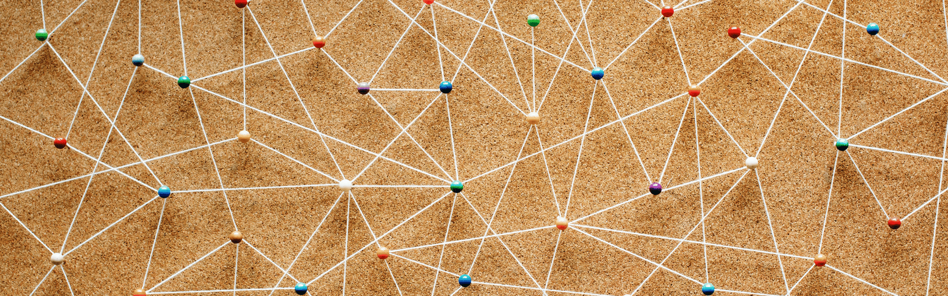 Un panneau en liège avec des épingles et des liens en ficelle entre elles